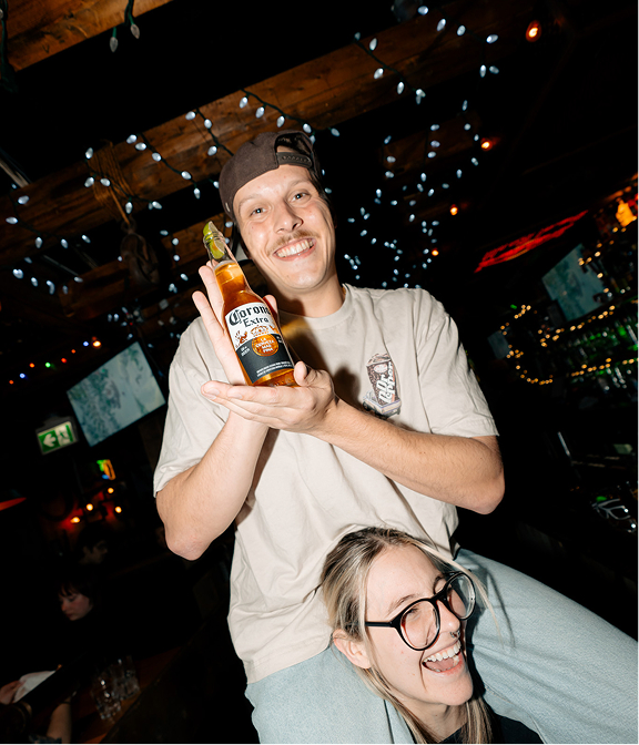 Guest holding a bottled beer during a lively night out at Warehouse.