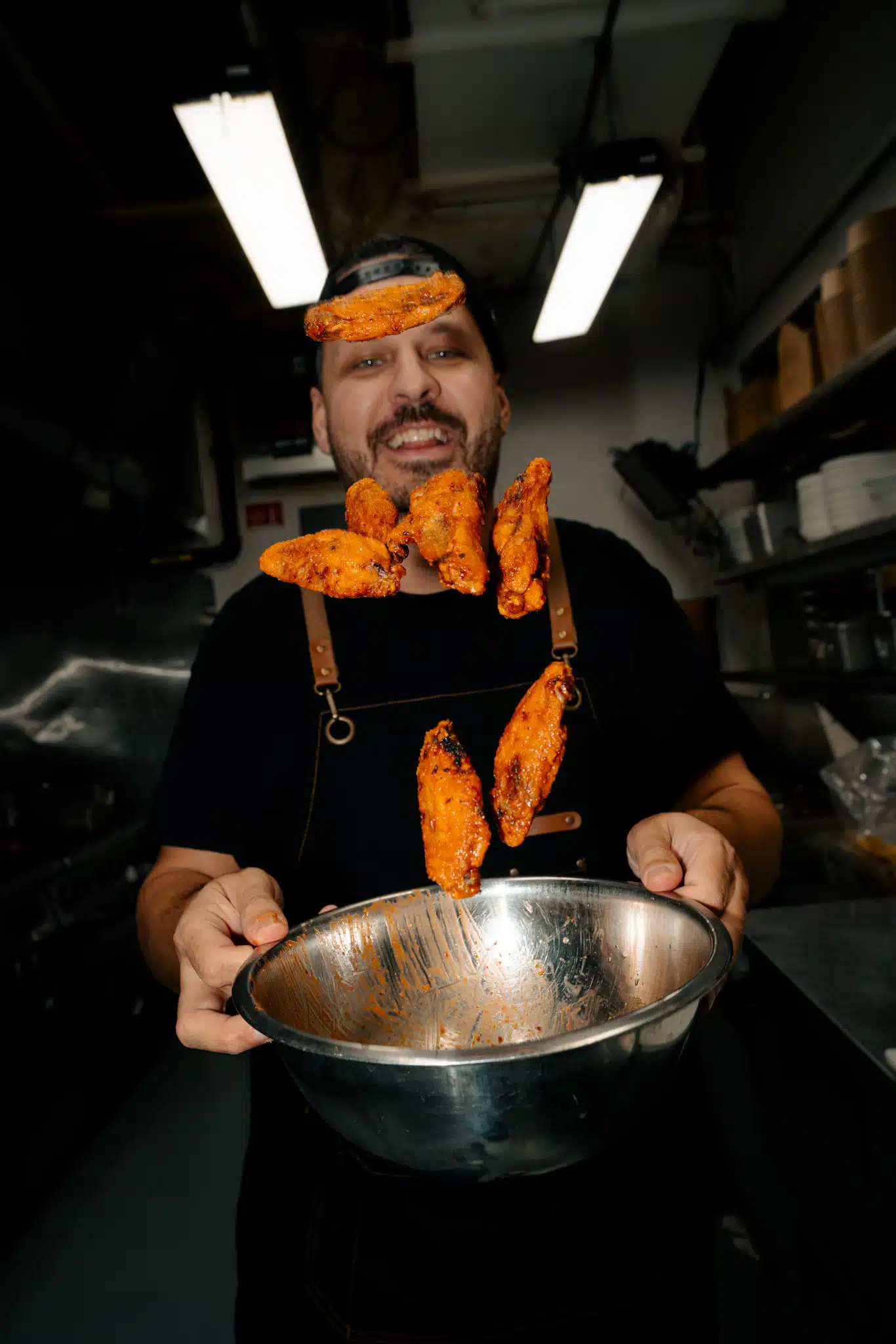 Chef tossing sauced chicken wings in the Warehouse kitchen.