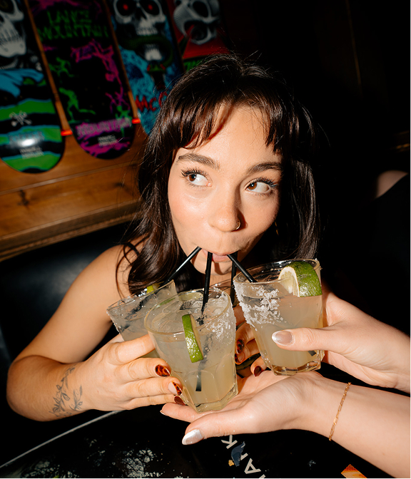 Guest sipping cocktails with friends during a night out at Warehouse.