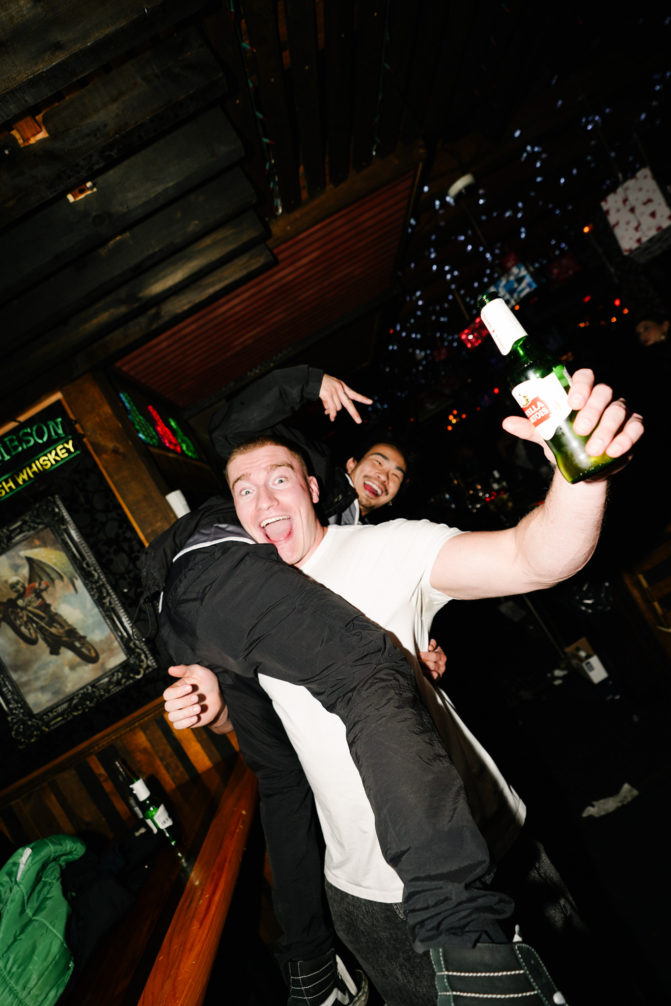 Friends celebrating with bottled beer during a lively night out at Warehouse.