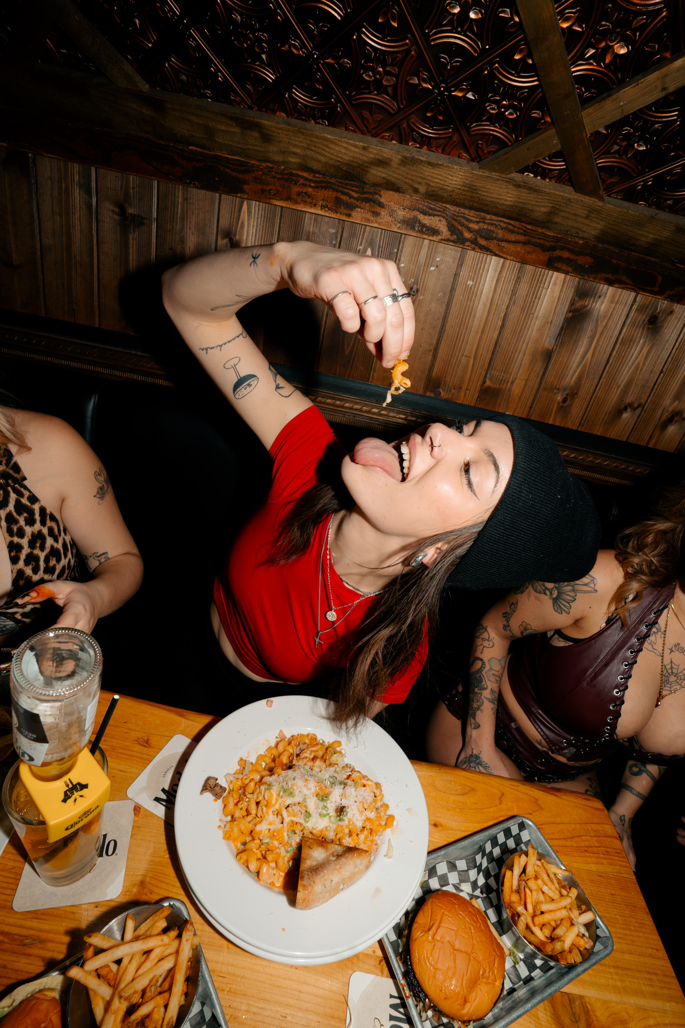 Guest enjoying pasta with burgers, fries, and drinks at a Warehouse table.
