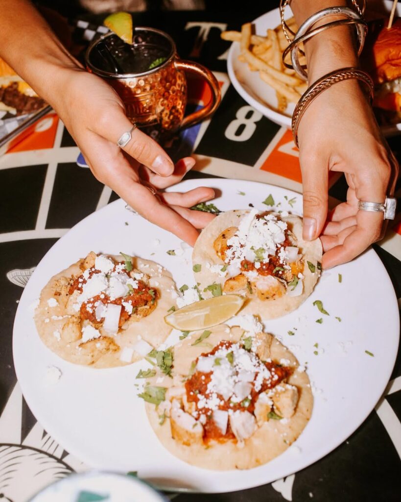Close-up of three flavorful street tacos stacked on a plate, showcasing fresh ingredients at Warehouse Vancouver.