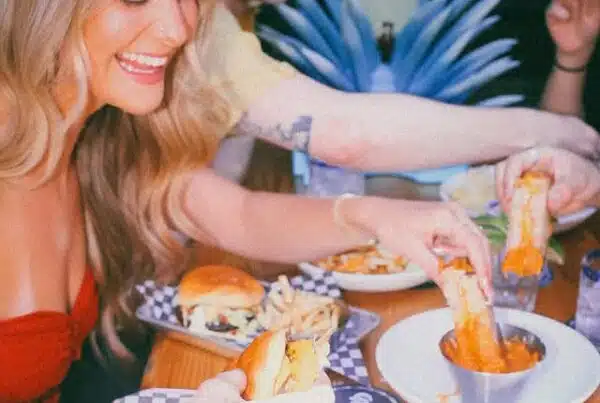A group enjoying burgers, fries, and fried pickles at Warehouse with lively vibes around the table.