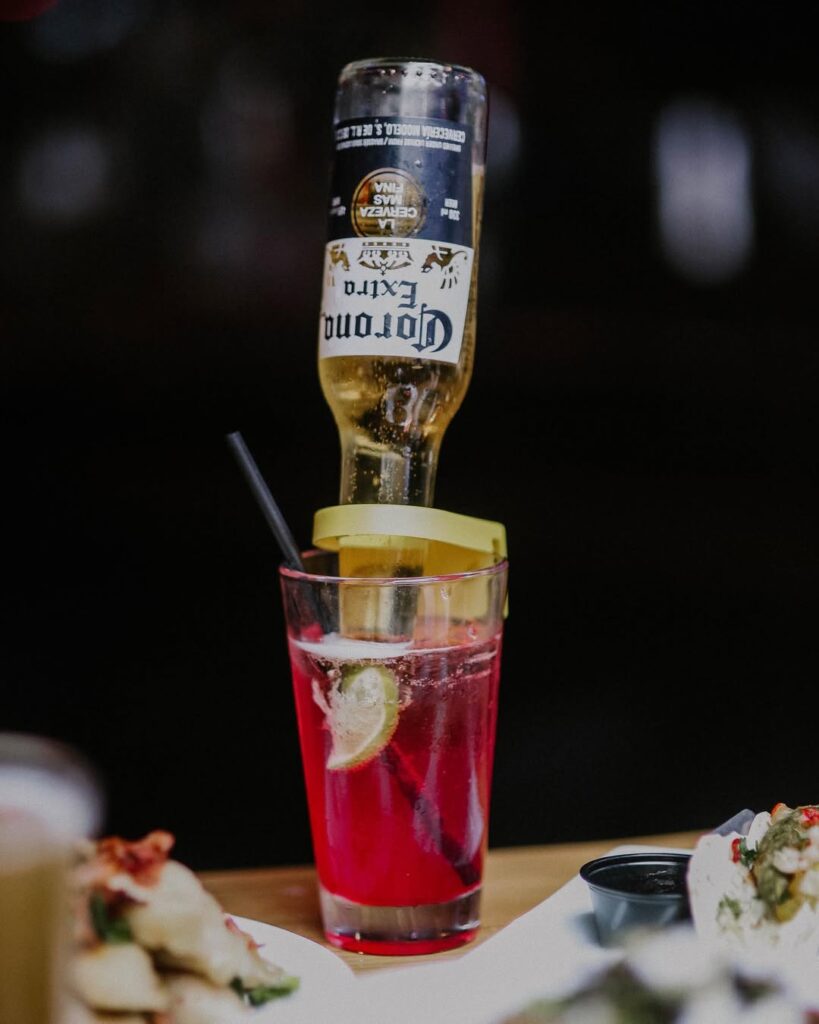 An image of our Signature ‘The Pink Warehouse’ cocktail being held by a lady.