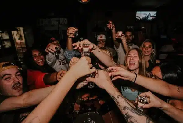 Group of students raising shot glasses together at Warehouse Montreal during happy hour.