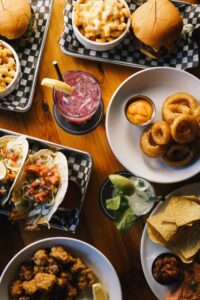 Table of tacos, burgers, onion rings, and drinks at Warehouse in Victoria BC.