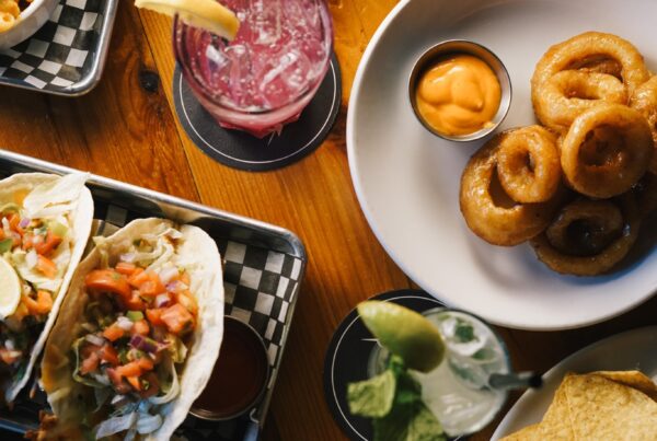 Table of tacos, burgers, onion rings, and drinks at Warehouse in Victoria BC.