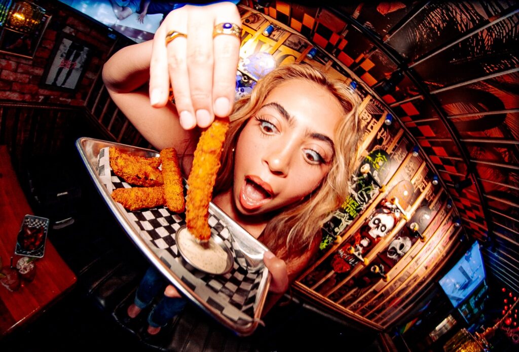  A woman dipping food in a dip at Warehouse Group.