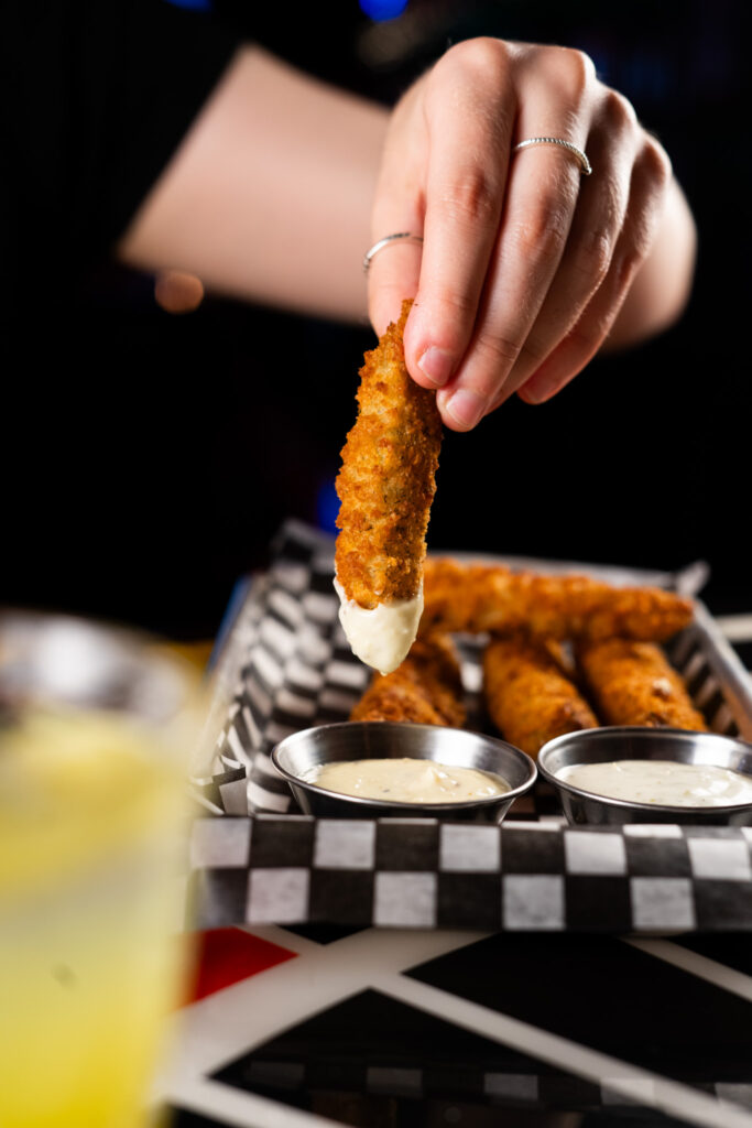 A close-up of crispy nachos dipped in creamy mayonnaise, a fan-favorite football snack at Warehouse Seattle.