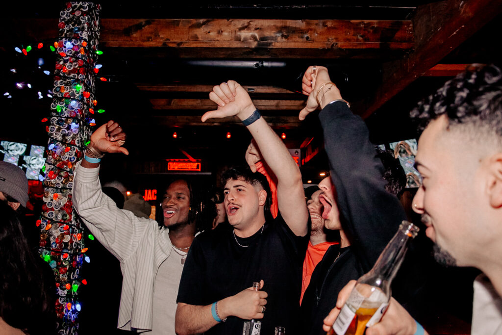 A lively, festive bar with colorful lights and good vibes, perfect for a pre-game or post-show gathering.