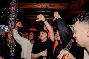 A lively, festive bar with colorful lights and good vibes, perfect for a pre-game or post-show gathering.