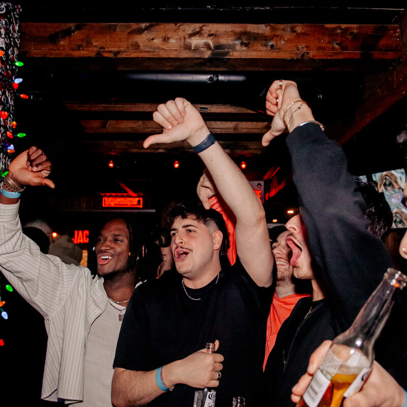 A lively, festive bar with colorful lights and good vibes, perfect for a pre-game or post-show gathering.