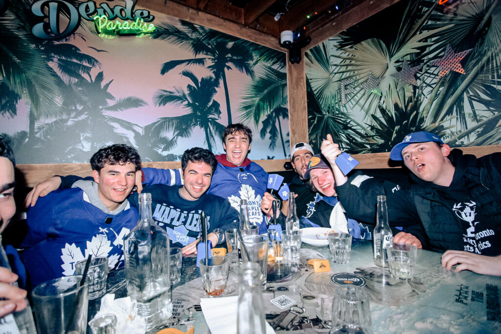 A Group of friends gathered around with drinks, geared up for the NHL.