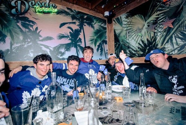 A Group of friends gathered around with drinks, geared up for the NHL.