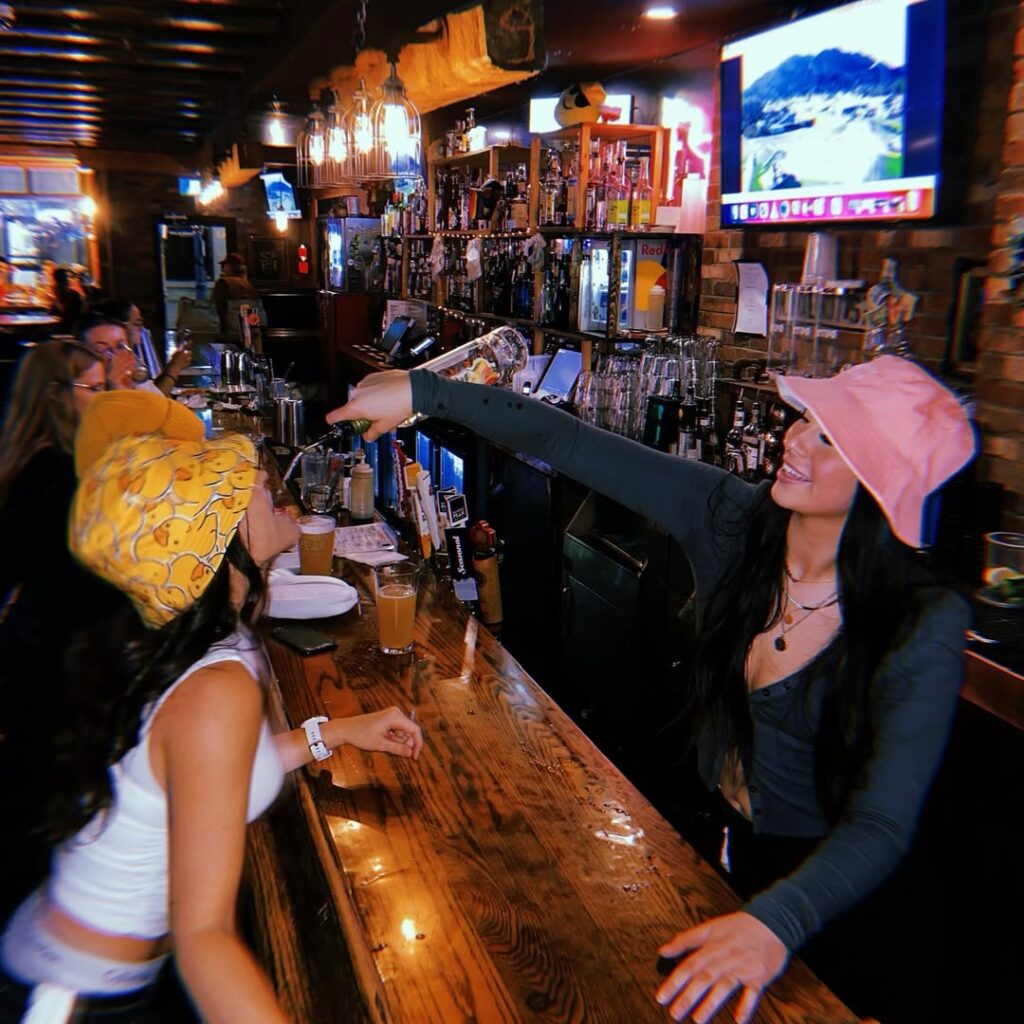 Bartender pouring multiple shots behind the bar at Warehouse Edmonton.