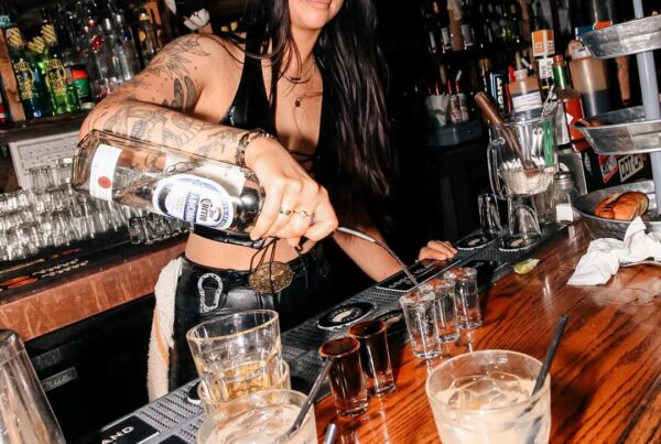 Bartender pouring a shot directly for a guest at Warehouse Edmonton bar.