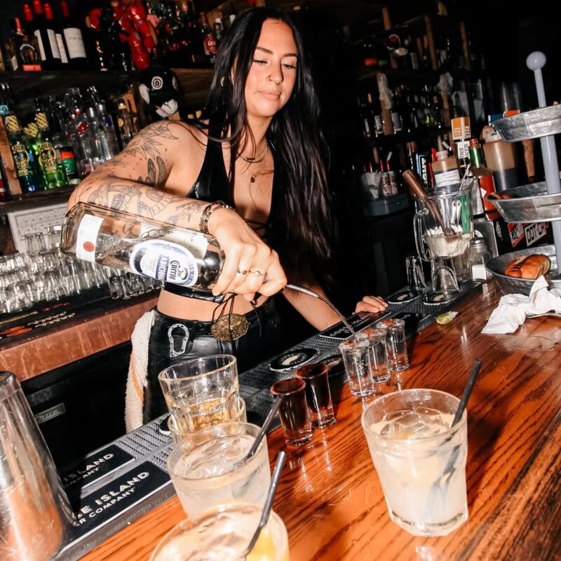 Bartender pouring a shot directly for a guest at Warehouse Edmonton bar.