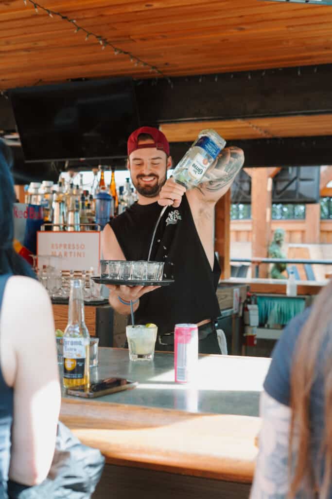 Warehouse bartender pouring drinks for patio guests on a summer day
