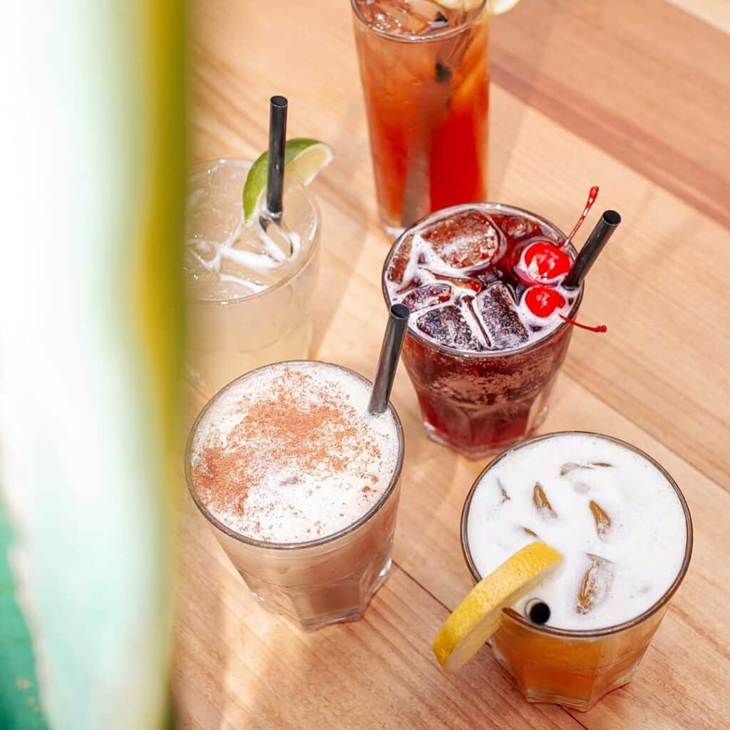 Colourful cocktails and highballs lined up on a table at Warehouse for a social night out.