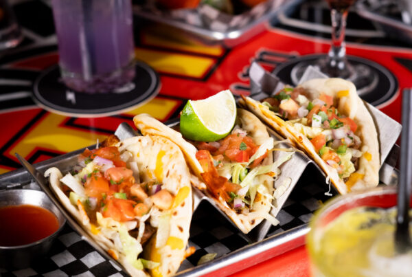 Tacos, cocktails, and drinks spread across a lively table at Warehouse during Victoria Day weekend.