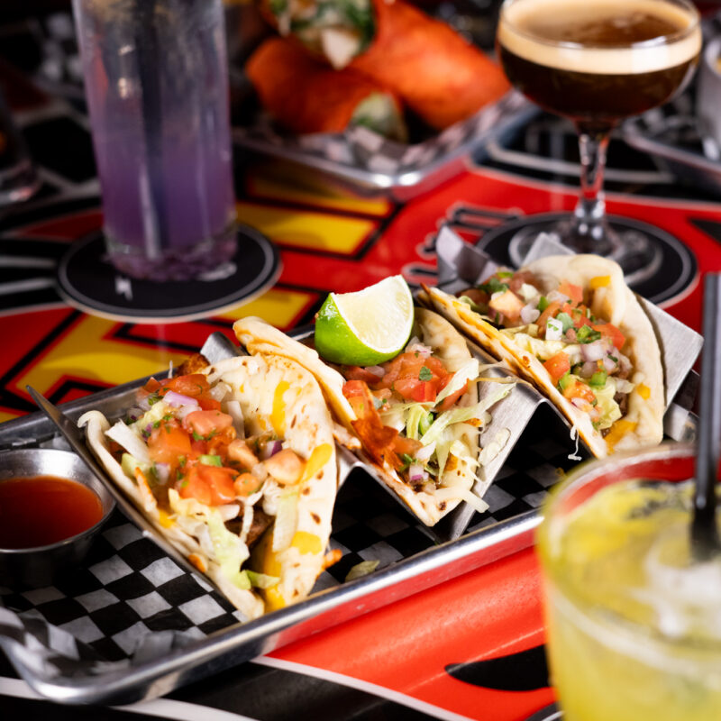 Tacos, cocktails, and drinks spread across a lively table at Warehouse during Victoria Day weekend.