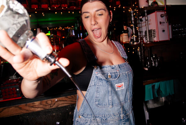 Bartender serving a round of shots to customers at Warehouse during a lively late-night afterparty.