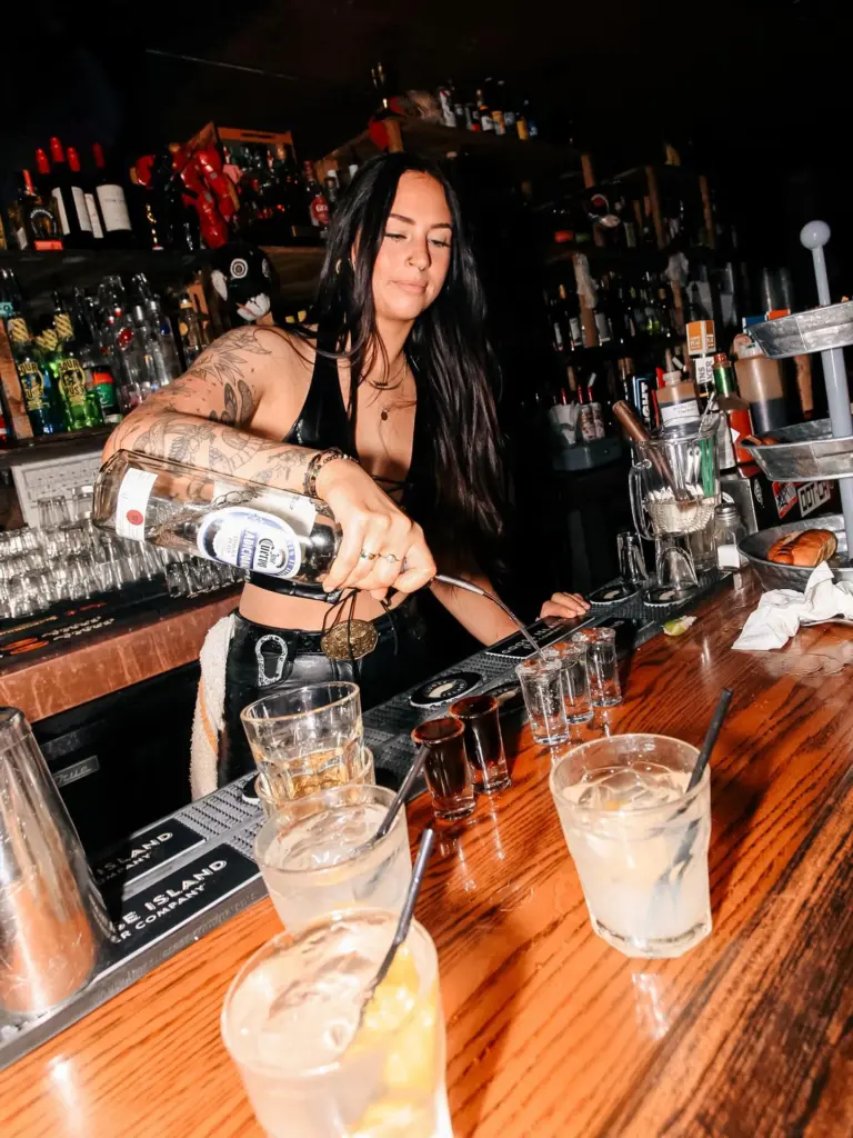 Bartender pouring a shot directly for a guest at Warehouse in Edmonton.