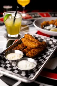 Fries, dipping sauces, and a drink on a table at Warehouse in Victoria.