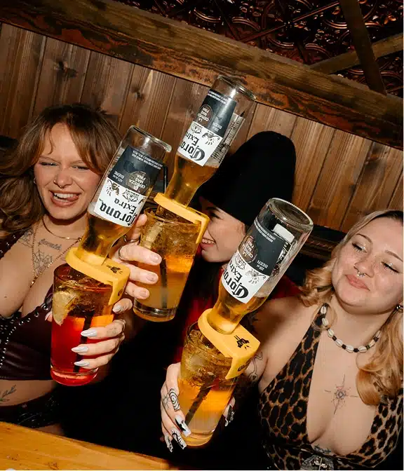 Friends enjoying cocktails and Corona Extra beers around a table at Warehouse.