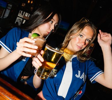 Two guests in jerseys holding drinks during a night out at Warehouse.